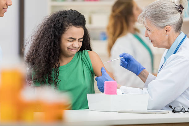 istock Young girl grimaces while receiving vaccine 2254067421