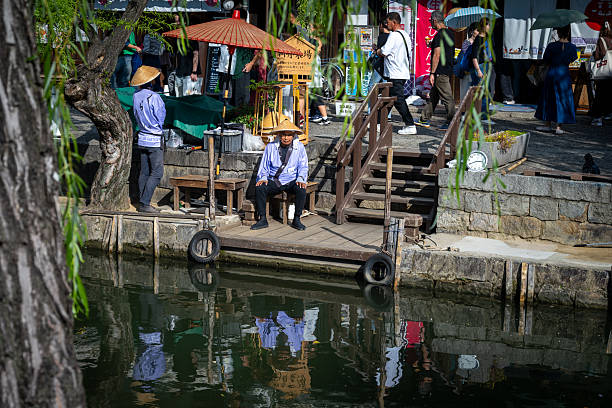 The boatmen wait for tourists at the water's edge to take them around Kurashiki