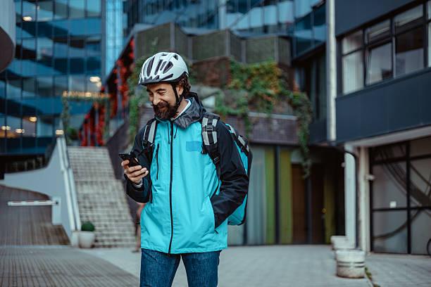 istock Happy Courier Using Phone App on City Street with Thermal Bag 2254068655
