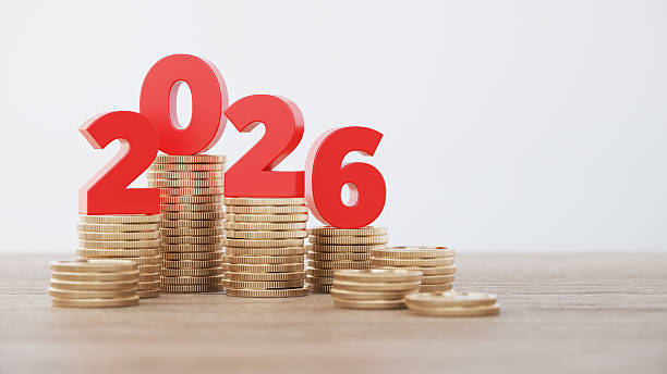 istock Red Colored 2026 Text and Coin Stack on Defocused Wooden Background 2254071314