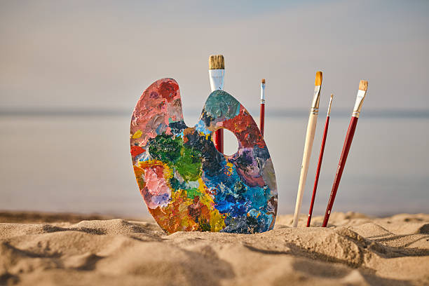 istock Artistic palette and brushes on serene beachfront 2254071878