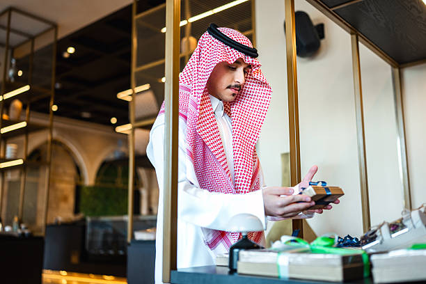 istock Young Arabic Man Choosing Gift Boxes in Upscale Restaurant Boutique 2254073036