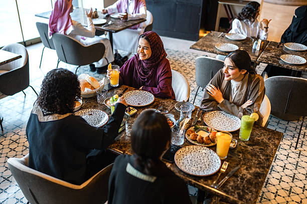 istock Delighted Young Arab Women Sharing Meal in Trendy Restaurant 2254073076