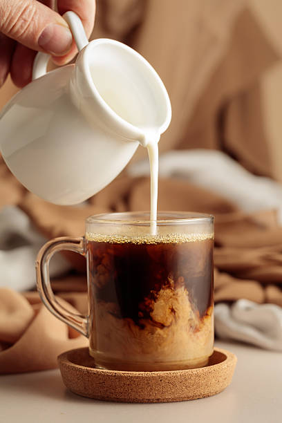 istock Pouring cream in black coffee. 2254076227