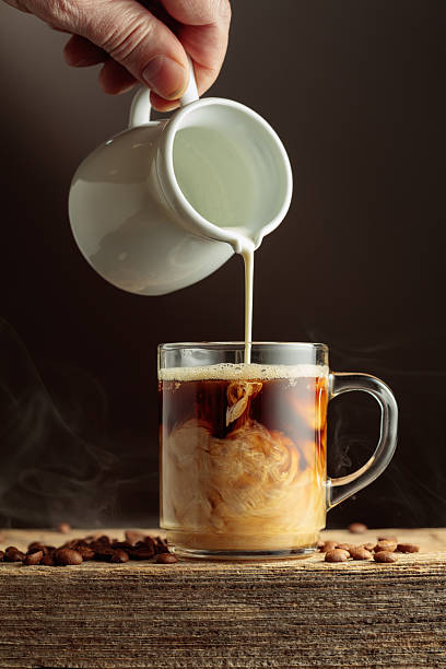 istock Coffee in a clear glass mug with cream being poured. 2254076264