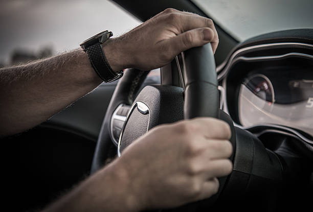 istock Driver Holds Steering Wheel While Driving on a Road in Daylight 2254079166