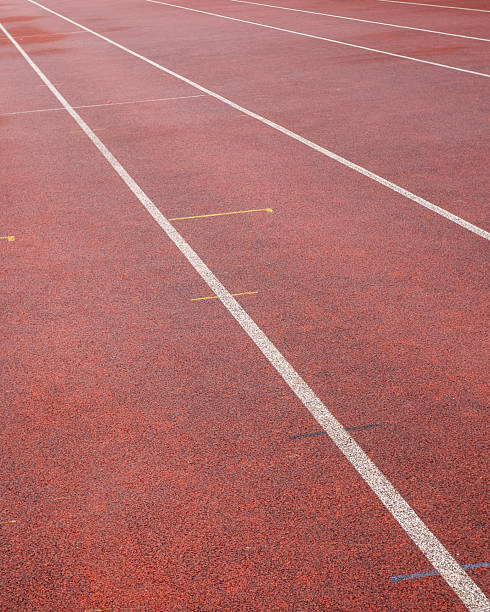 istock Running track surface with marked lanes in bright red color showcasing athletic space for training and competitions 2254079888
