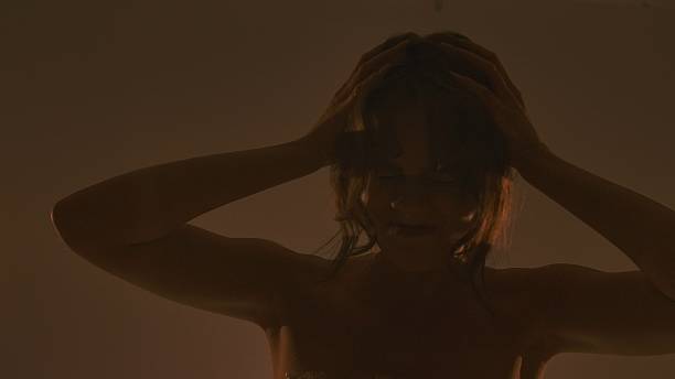 Female silhouette holding her head in smoke