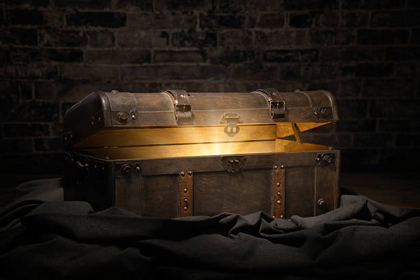 Vintage treasure chest in a dark dungeon opens to reveal a luminous but hidden secret