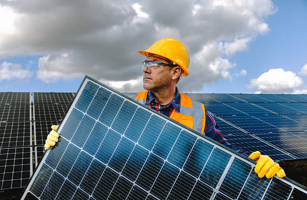 istock Solar Maintenance Expert: Portrait of Smiling Maintenance Worker Man Holding a Solar Panel Module in Photovoltaic Farm Power Energy Station 2254084831