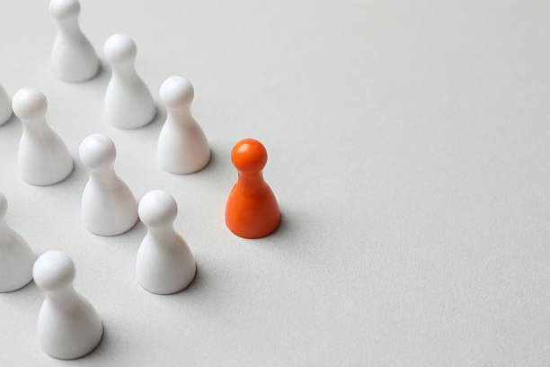 istock Group of colored pawns on the table. Concept of unity 2254090529