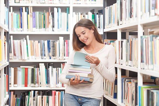 istock Happy Female Student Holding Books in Library 2254091617