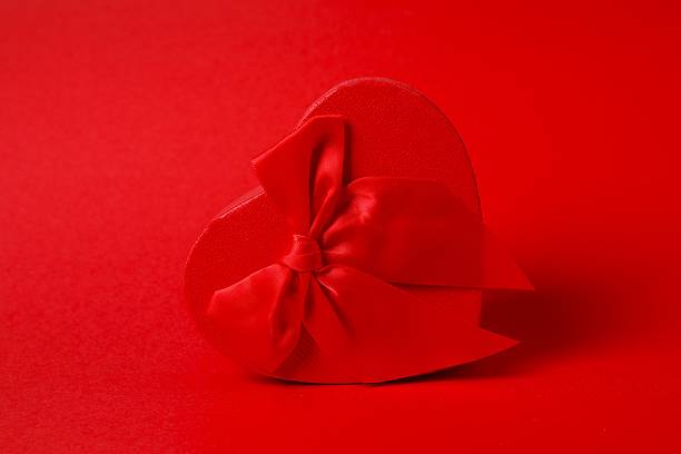 Festive gift box with red bow on color background