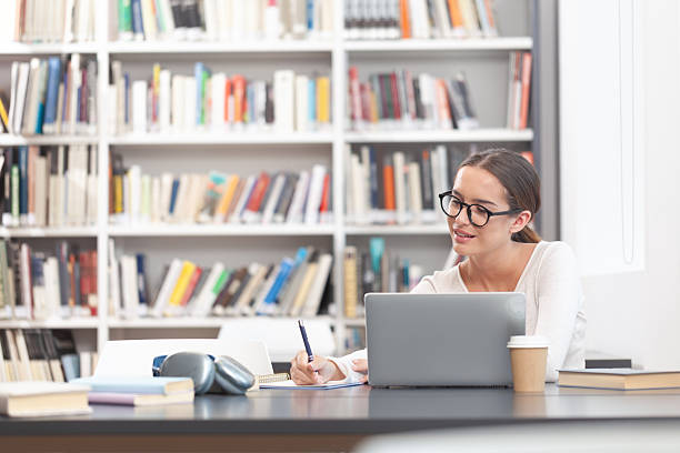 istock Young female university student studying at a desk in the college library 2254091844