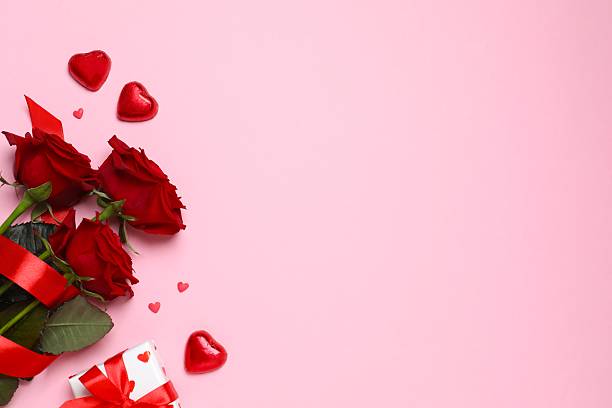 istock Beautiful red roses, gift box and hearts on pink background 2254091981
