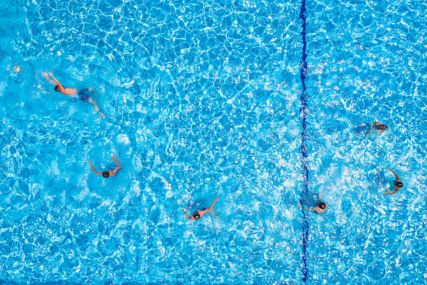 Swimming pool with playing people, overhead view