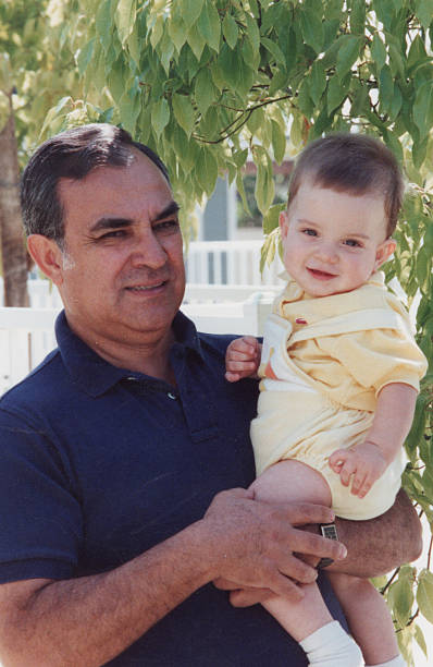 istock Hispanic mature man holding his grandson posing inside his home 2254107479