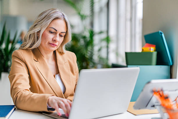 istock Business women working together in a modern office environment on various projects using technology and sharing ideas 2254109244