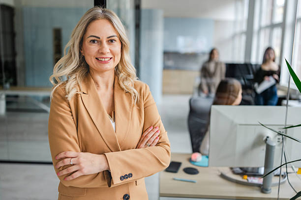 istock Businesswoman in office smiling confidently while colleagues work on team project in modern workspace 2254110203