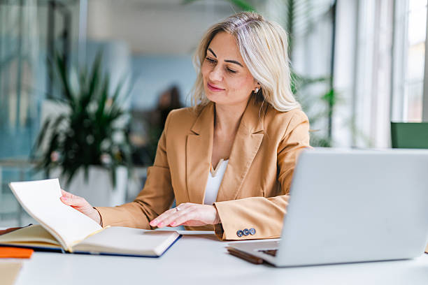 istock Businesswoman reviewing notes while working at desk in modern office during daytime 2254110372