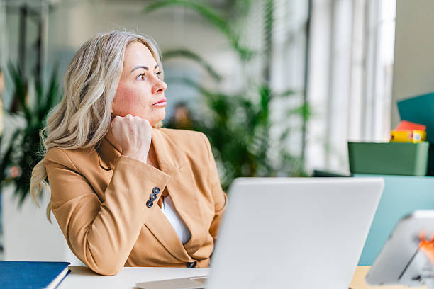 istock Businesswoman working in an office thoughtfully contemplating next steps while collaborating with colleagues and managing tasks 2254112229