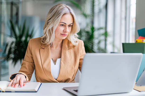 istock Businesswoman working in modern office, focused on laptop and taking notes for new project development 2254112617