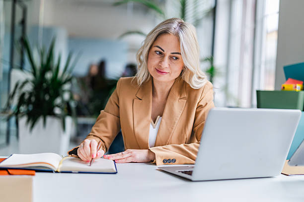 istock Businesswoman working in office during daytime, focused on notes and laptop 2254112632