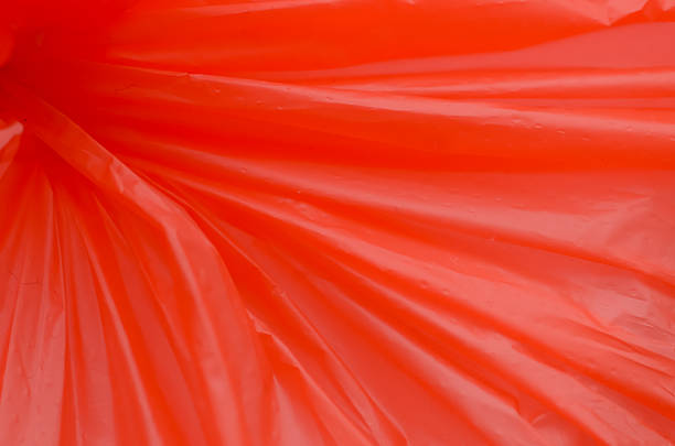 Abstract Close-Up of Vibrant Reddish-Orange Plastic Material with Sharp Radiating Folds and Texture