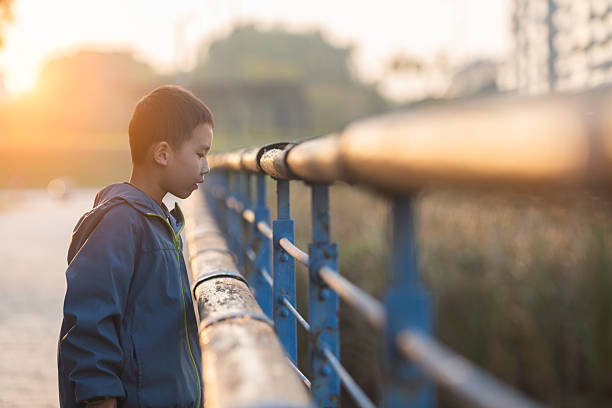 a student poses at a railway station, a teenage boy walks along the platform to the train, he has a backpack and books, goes to study, the concept of education