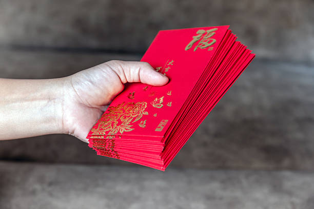 istock Hand holding red envelopes with golden (Fu) symbol, representing luck, prosperity, and blessings for Lunar New Year or Chinese New Year celebration 2254126350