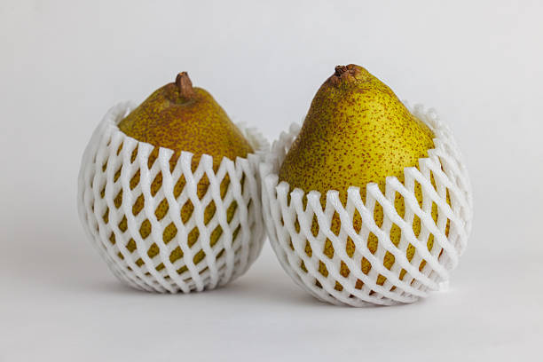 La France pears in protective mesh sleeves on white background
