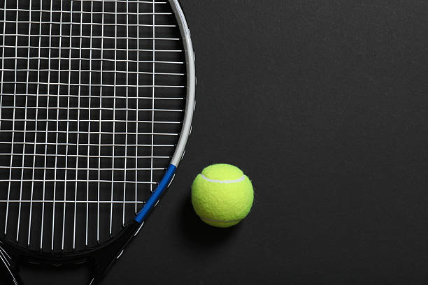 istock Tennis racket and ball on black background 2254130361