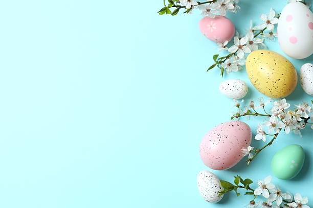 istock Happy Easter. Colorful eggs and white spring flowers on color background, space for text or advertising 2254132724