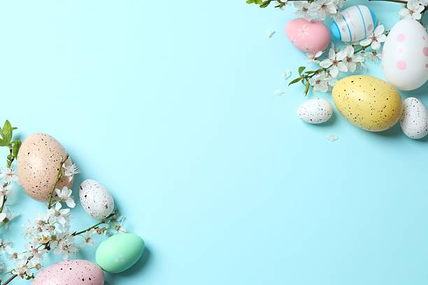istock Happy Easter. Colorful eggs and white spring flowers on color background, space for text or advertising 2254132728
