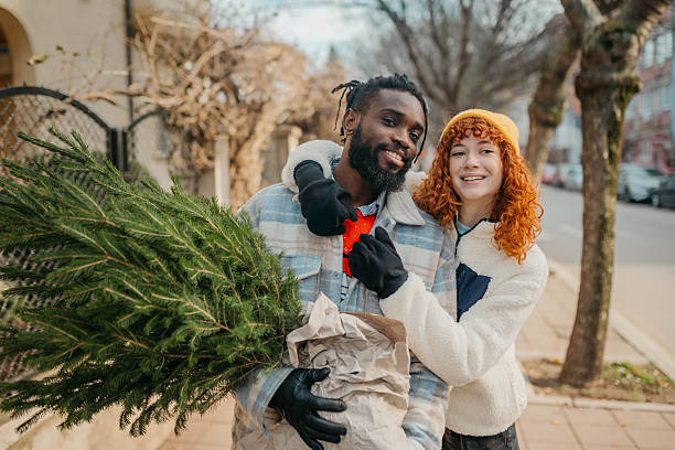 istock Smiling couple using carrying the Christmas tree 2254138151