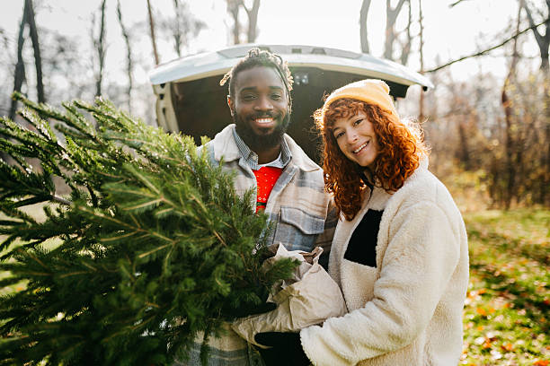 istock A woman and a man are loading a Christmas tree into the car. 2254138178