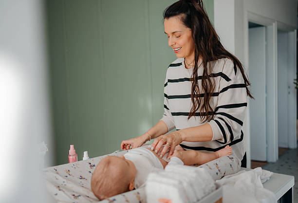 istock Mom is changing the baby's clothes. 2254140257
