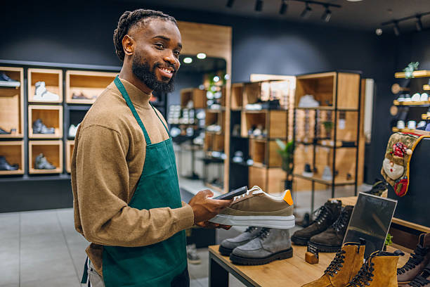 istock Shoe store salesman using a phone 2254141540