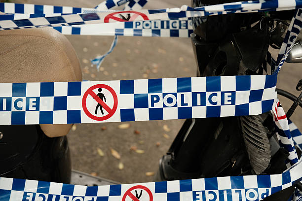 Blue and white Police barricade tape around a motorcycle.