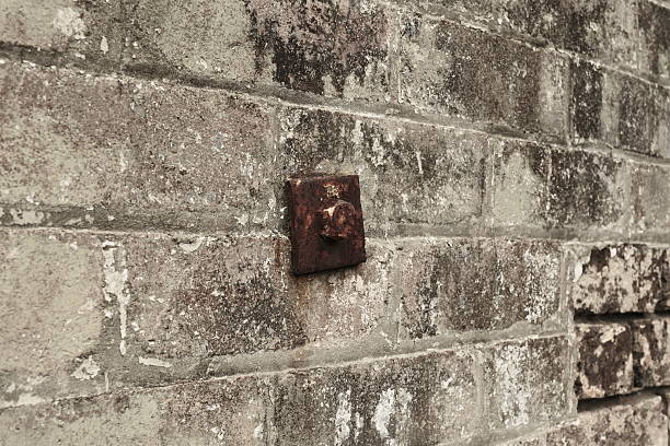 Close-up on a rusty metal bolt in an old brick wall.