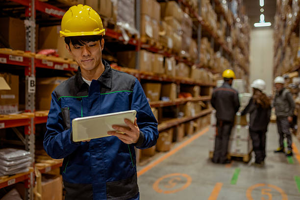 istock Warehouse Worker Using Tablet for Inventory Management in Large Distribution Center 2254143399