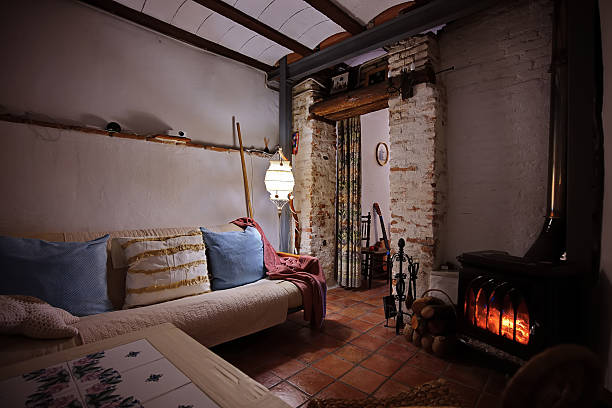 A cozy rustic living room featuring a cushioned sofa, warm fireplace, and rustic accents. Soft lighting creates a welcoming, homely atmosphere perfect for relaxation.