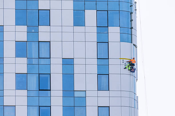 6 November 2025, Batumi, Georgia: Worker performing high rise window cleaning service, demonstrating industrial hygiene and dangerous job