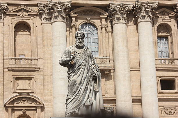 majestic marble statue of Saint Peter holding the Keys of Heaven, standing in front of the facade of St. Peter's Basilica in the Vatican.