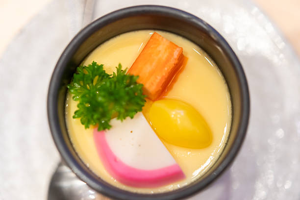 Japanese steamed egg custard or Chawanmushi served in a black ceramic cup