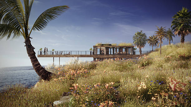 A modern elevated eco house with a green roof extends over the ocean, blending minimalist coastal architecture with untouched wildflowers and natural shoreline terrain. Concept image of future sustainable travel and architecture in harmony with nature. (3D render)