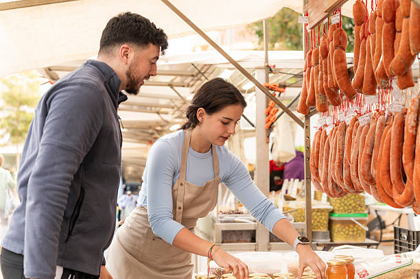 Vendor selling local products to customer at market stall