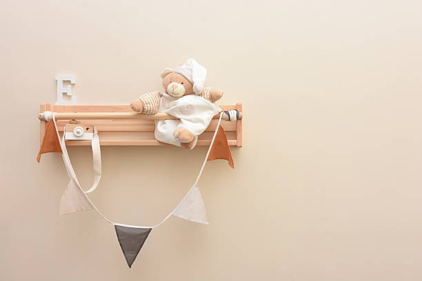 a shelf with a rag doll, a wooden letter E and a wooden toy camera