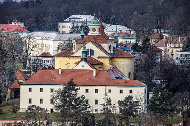 istock Historic monastery complex with red tiled roofs and green domes against a backdrop of trees 2254152049