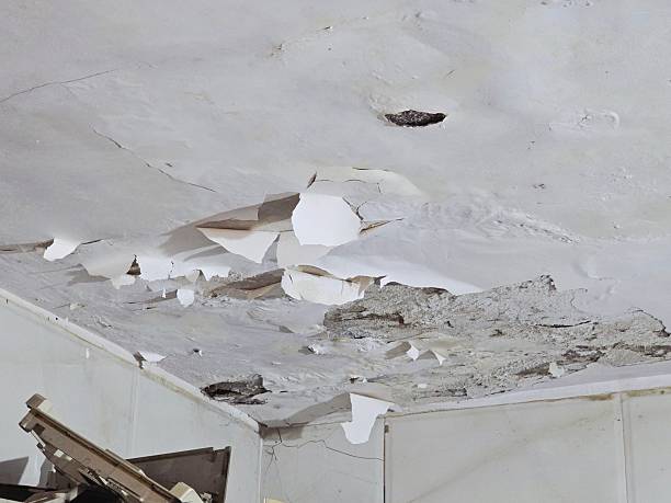 istock Peeling and Cracked Ceiling with Falling Plaster Showing Water Damage Inside Old Building 2254153845